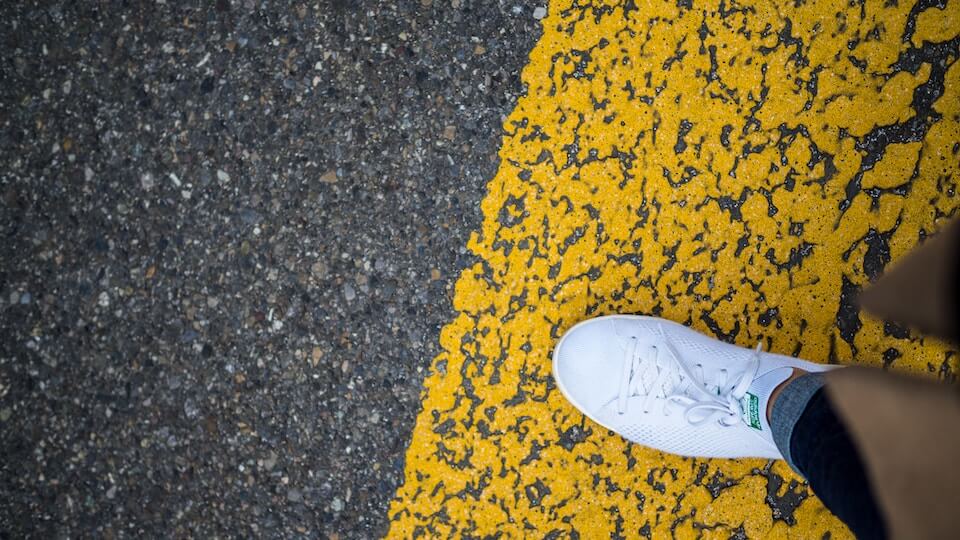 A white shoe on a yellow line on a road